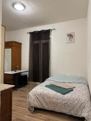 a bedroom with a bed and a desk and a window at Votre Havre de Paix à Perpignan in Perpignan