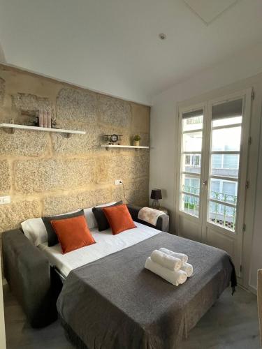 a bedroom with a large bed with orange pillows at Apartamentos SARABIA DARRIBA in Ourense