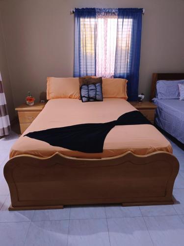 a large bed in a room with a window at Pensão Dona Fica in Tarrafal