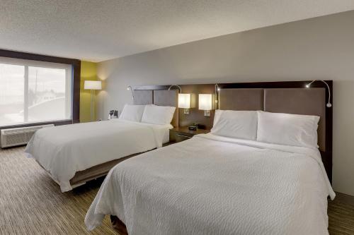 a hotel room with two beds and a window at Holiday Inn Express Hotel & Suites Bryan-Montpelier by IHG in Holiday City