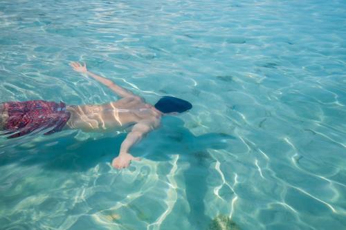 a man swimming in the water in the ocean at The Ritz-Carlton, Grand Cayman in George Town