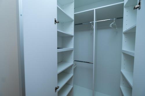 a walk in closet with white shelves at Sanja & Mirza Apartments - Old Town Sarajevo in Sarajevo
