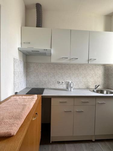 a kitchen with white cabinets and a sink at Studio Cosy - Cœur Perpignan in Perpignan