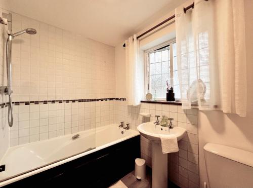 a white bathroom with a tub and a sink and a bath tub at Hilltop walkers paradise with a view, sleeps 10 in Fernhurst