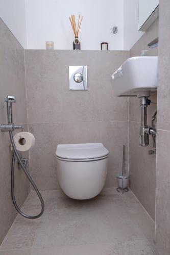 a bathroom with a white toilet and a sink at Sanja & Mirza Apartments - Old Town Sarajevo in Sarajevo