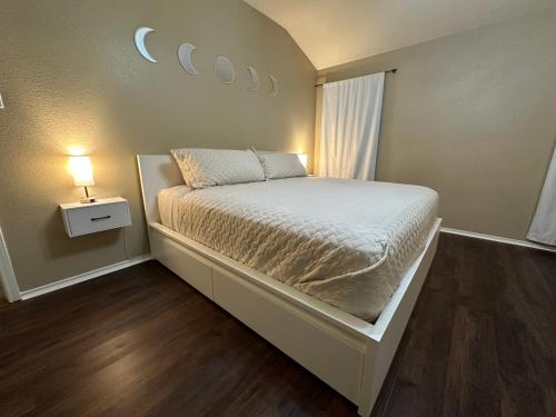 a small bedroom with a bed and a lamp at Sunset Zen Space in Killeen