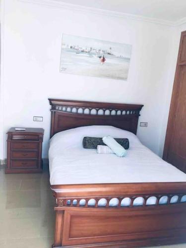 a bedroom with a bed with a wooden head board at Sol Beach, Cabo Roig in Orihuela Costa