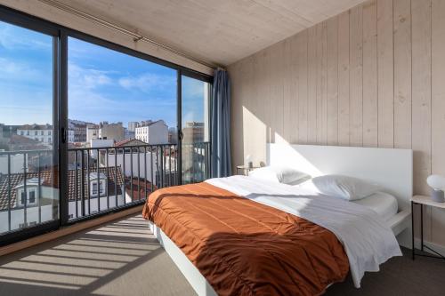 - une chambre avec un lit et une grande fenêtre dans l'établissement Grand appartement moderne très proche de Paris centre, à Malakoff