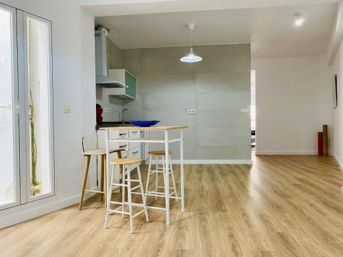a kitchen with a counter and stools in a room at El ventanal del viajero in Baeza