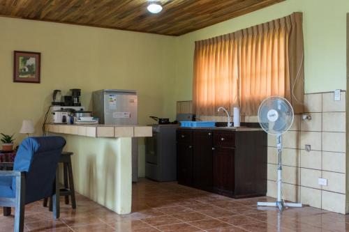 eine Küche mit einer Theke und einem Ventilator in einem Zimmer in der Unterkunft Butterfly Dance studio apartment, San Ramon in Santiago