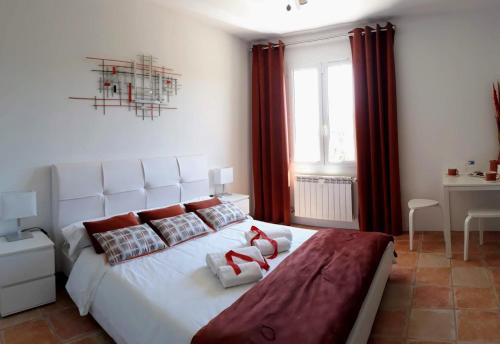 Schlafzimmer mit einem großen weißen Bett und roten Vorhängen in der Unterkunft BELLA VISTA 2 chambres d'hôtes 4 personnes in Salernes