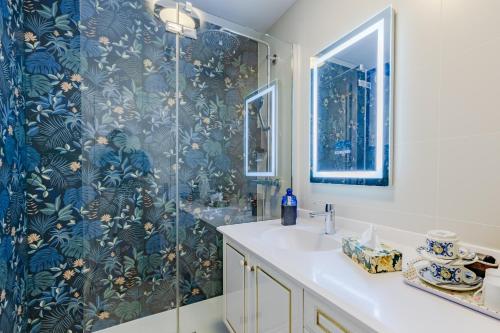 W łazience znajduje się prysznic i biała umywalka. w obiekcie Chambre d'Amis - Chambres d'Hôtes-B&B-Guest House w Paryżu