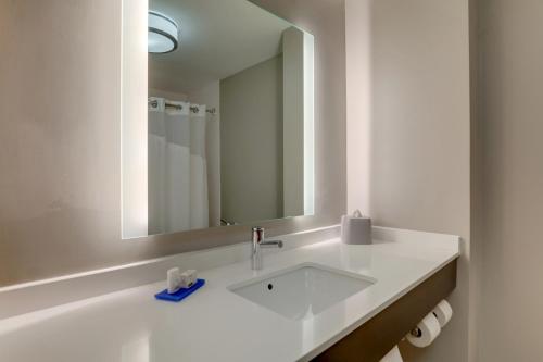 a white bathroom with a sink and a mirror at Holiday Inn Express Hotel & Suites Bryan-Montpelier by IHG in Holiday City