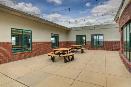 a patio with benches and tables on a building at Holiday Inn Express Hotel & Suites Bryan-Montpelier by IHG in Holiday City