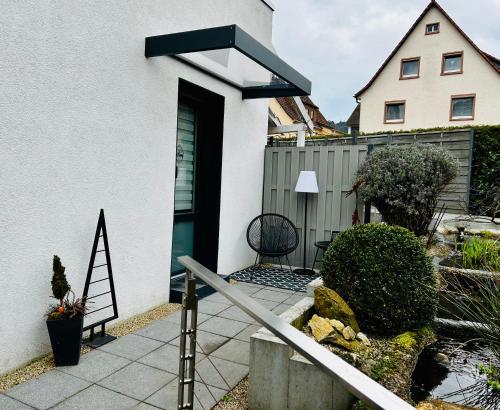 a white house with a green door and a fence at LIVE-IN Tiny Studiowohnung in Wertheim