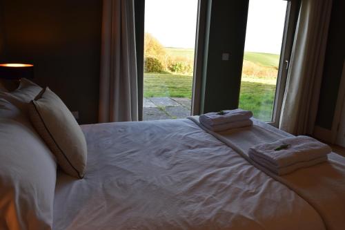 a bed with towels on it with a window at Cedarblue in Dungarvan