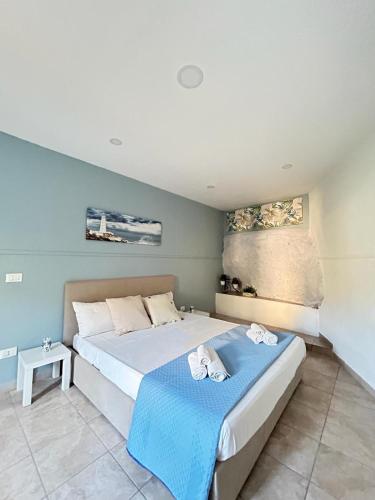 a bedroom with a large bed with a blue blanket at Taormina Stone Home in Taormina