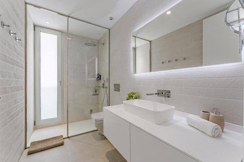 a white bathroom with a sink and a mirror at Villa Larisa in Callao Salvaje