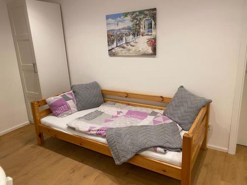 a bedroom with a wooden bed with two pillows at Schöne Wohnung nahe Nürnberg, 60 qm, 3 Pers. WLAN in Stein