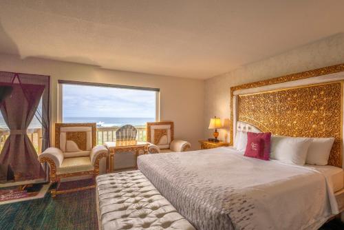 um quarto com uma cama grande e uma janela grande em Ocean View Lodge em Fort Bragg