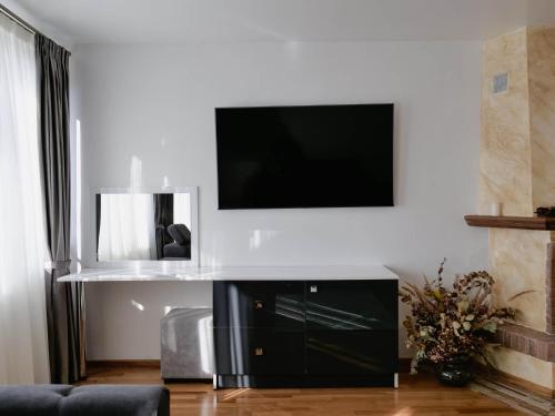 a living room with a flat screen tv on a wall at Casa YDA in Horezu