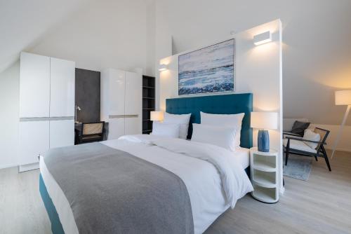 a bedroom with a large bed with a blue headboard at ATLANTIC Grand Hotel Travemünde in Travemünde