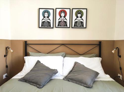 a bed with four pictures on the wall above it at Noù la tua casa in Puglia in Alberobello
