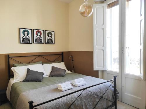 a bedroom with a bed with three pictures on the wall at Noù la tua casa in Puglia in Alberobello
