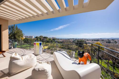 un chien assis sur un toboggan sur un balcon dans l'établissement 06BK - Superb contemporary sea-view villa, à Cagnes-sur-Mer