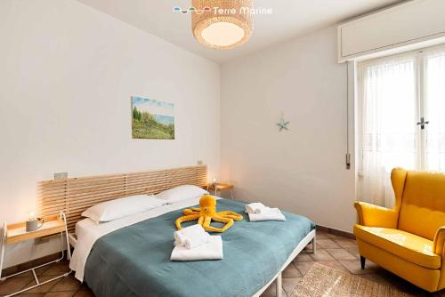 a bedroom with a large bed with a yellow chair at La Tana del Polpo in Monterosso al Mare