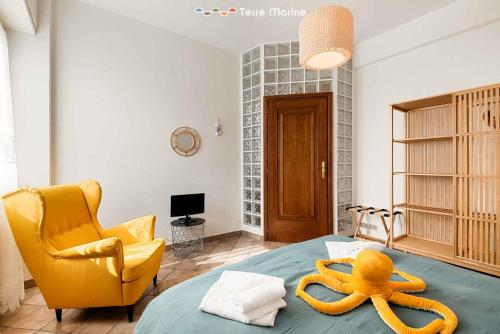 a bedroom with a bed with a yellow chair and an octopus on it at La Tana del Polpo in Monterosso al Mare