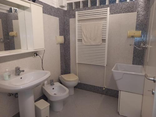a white bathroom with a sink and a toilet at HOME SWEET HOME in Rovereto