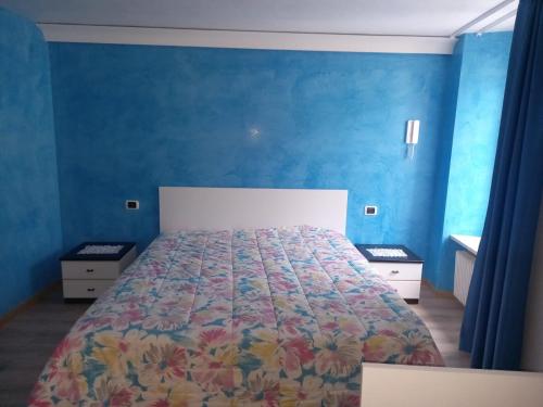 a bedroom with a large bed with blue walls at HOME SWEET HOME in Rovereto