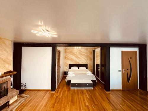 a large bedroom with a bed and a fireplace at Casa YDA in Horezu