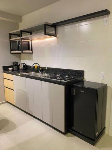 a kitchen with a black and white counter top at Studio alto padrão confortável sem taxa de limpeza in Cachoeira do Sul