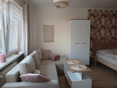 Sala de estar blanca con sofá y mesa en Apartament w Srebrnym Mieście en Tarnowskie Góry