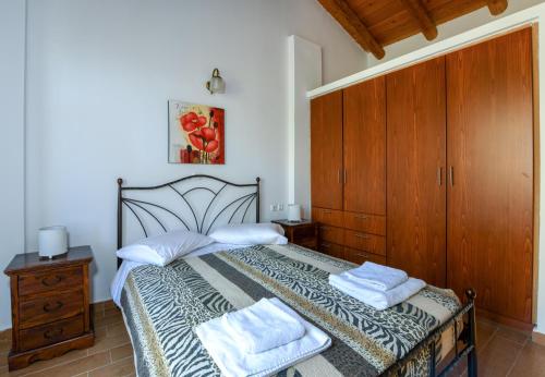 a bedroom with a bed with two towels on it at Malathiros Traditional Villas in Maláthiros