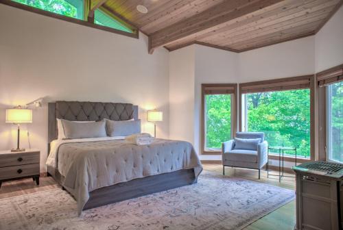 een slaapkamer met een bed, een stoel en ramen bij Sunrise Kingdom in Cullowhee NC in Cullowhee