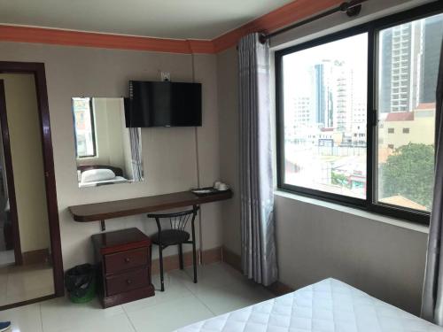 a hotel room with a desk and a window at RS Galaxy HOTEL in Phnom Penh