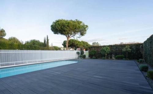 a swimming pool in a yard with a white fence at Luxurious Villa Vilamoura in Vilamoura