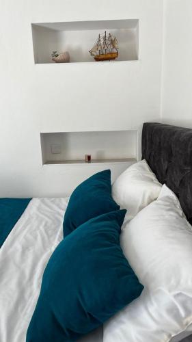 a bed with blue and white pillows on it at STR Apartment in Tivat