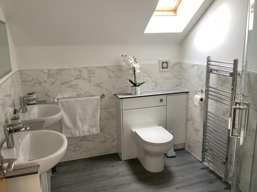 a bathroom with two sinks and a toilet and two sinks at Peaceful relaxing home with leisure in Saint Columb Major