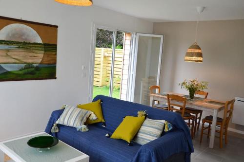 un salon avec un canapé bleu et une table dans l'établissement La maison Des Cordelles, à Saint-Denis-en-Val