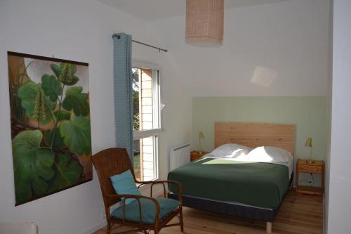ein Schlafzimmer mit einem Bett, einem Stuhl und einem Fenster in der Unterkunft La maison Des Cordelles in Saint-Denis-en-Val