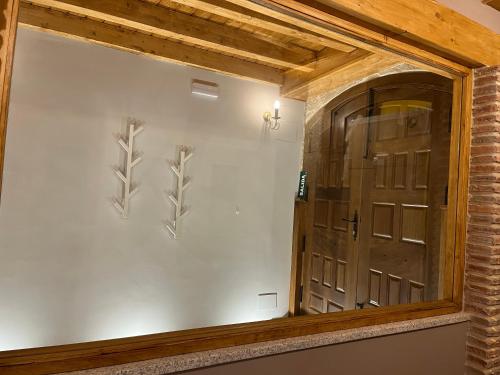 a mirror in a room with a door at Las Musas, Casa Rural in Hervás