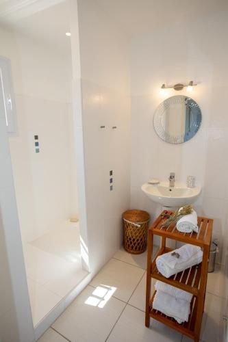 une salle de bain blanche avec une douche et un lavabo dans l'établissement Résidence Pietri, à Calcatoggio