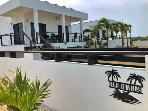 Una casa blanca con un cartel en el costado. en Samudra Villas 1, en San Pedro