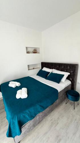 a bedroom with a large bed with a blue blanket at STR Apartment in Tivat