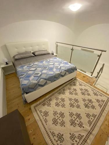 a bedroom with a bed and a rug at Donna Cuncetta Soppalco Monte di Procida in Monte di Procida