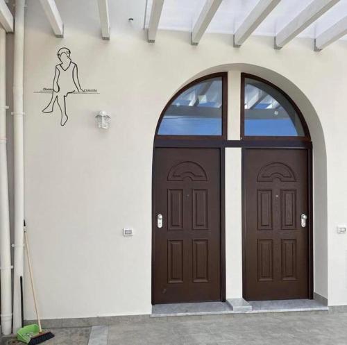 a door with a drawing of a woman sitting on a branch at Donna Cuncetta Soppalco Monte di Procida in Monte di Procida